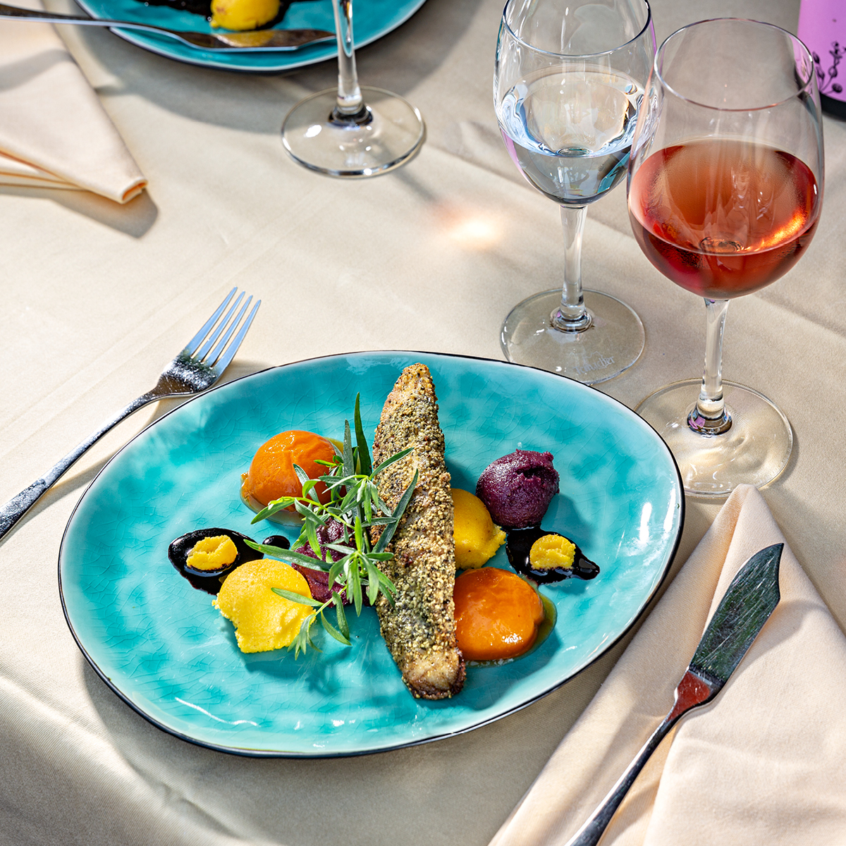Das Bild zeigt einen fein gedeckten Tisch und ein Fischgericht.